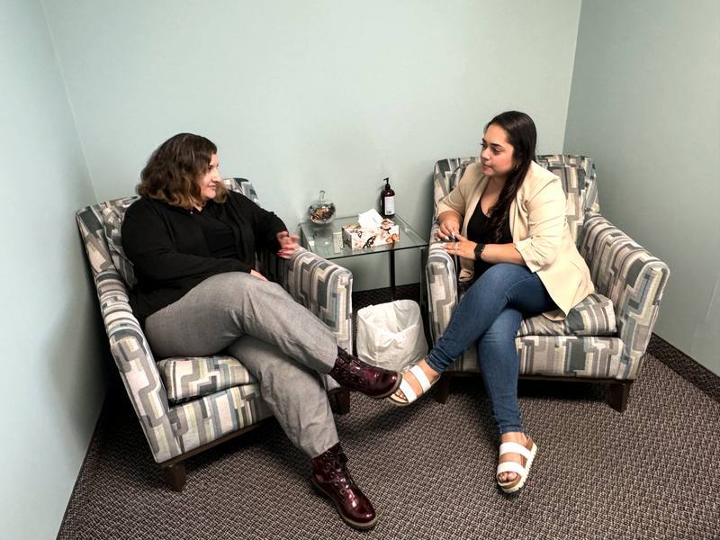 Two people talking in armchairs at the clinic